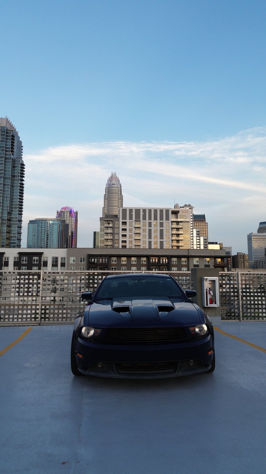 Ford Mustang on a rooftop parking deck with the Uptown Charlotte skyline behind it